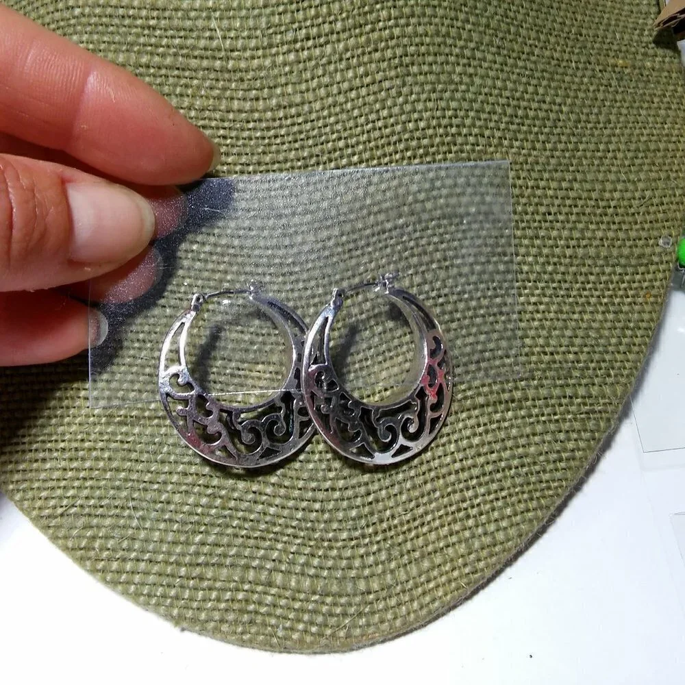 Women`s silver tone filigree hoop earrings. 1 1/8